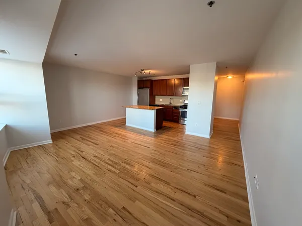 a view of empty room with wooden floor