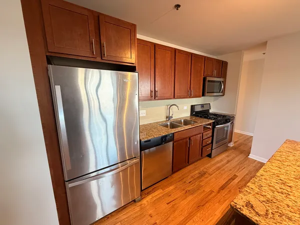 a kitchen with granite countertop stainless steel appliances and wooden cabinets