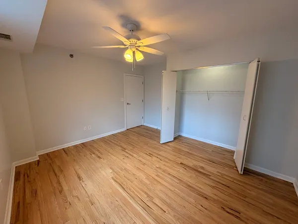 a view of empty room with wooden floor