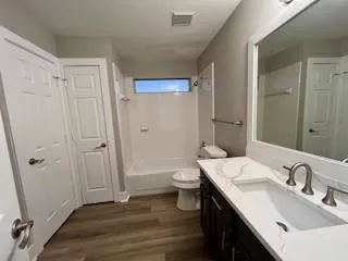 a bathroom with a double vanity sink toilet and shower