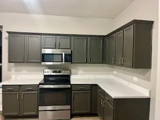 a kitchen with kitchen island a sink appliances and cabinets