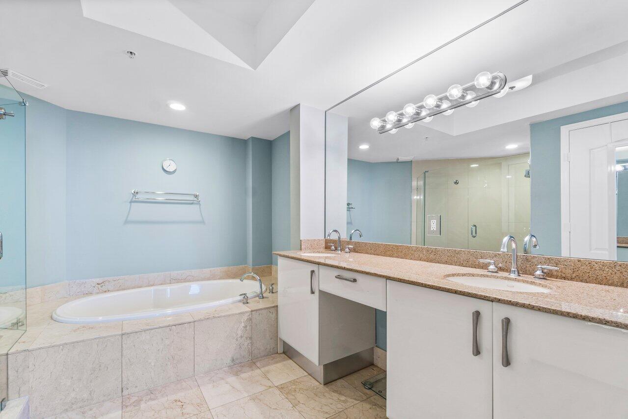191 Southeast 20th Avenue, Unit 513 Deerfield Beach, FL 33441 - Photo 16 of 34 a bathroom with a granite countertop sink a large mirror and a bathtub