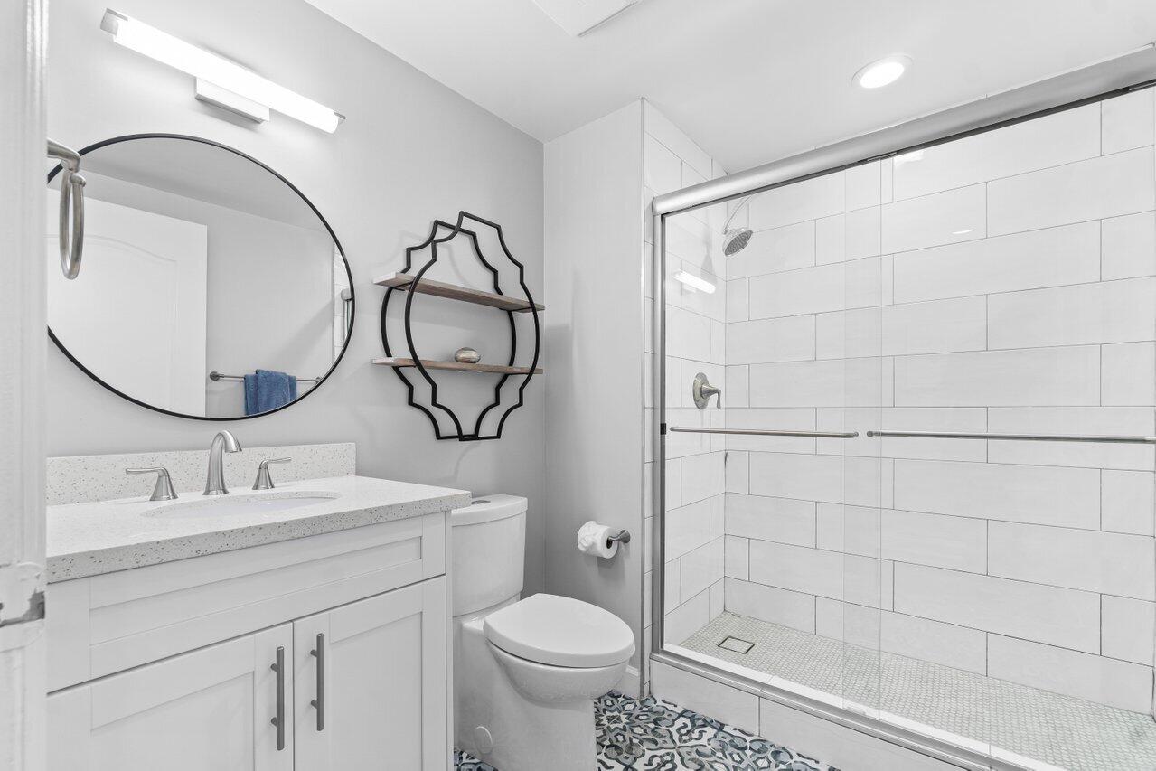 191 Southeast 20th Avenue, Unit 513 Deerfield Beach, FL 33441 - Photo 19 of 34 a bathroom with a sink a toilet and a mirror