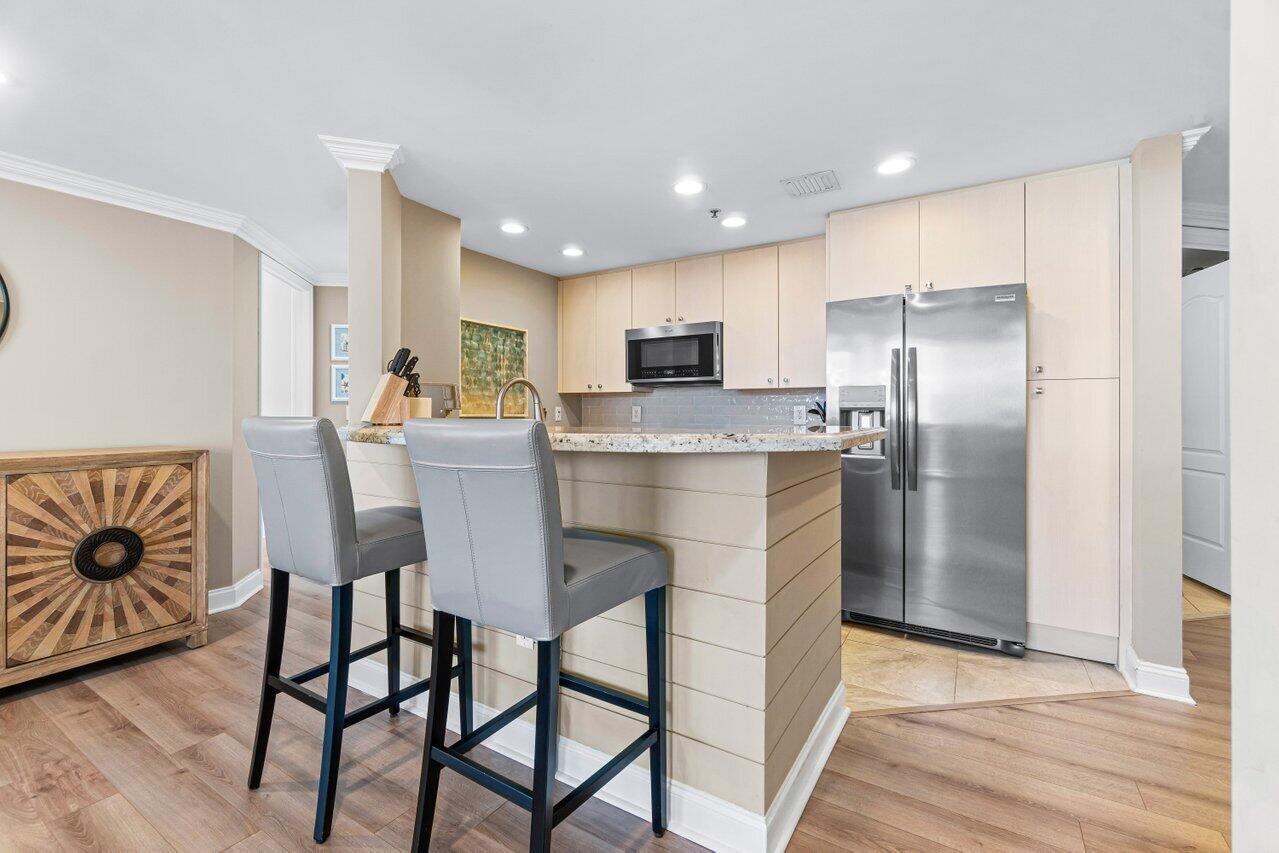 191 Southeast 20th Avenue, Unit 513 Deerfield Beach, FL 33441 - Photo 7 of 34 a kitchen with stainless steel appliances granite countertop a dining table chairs refrigerator and sink
