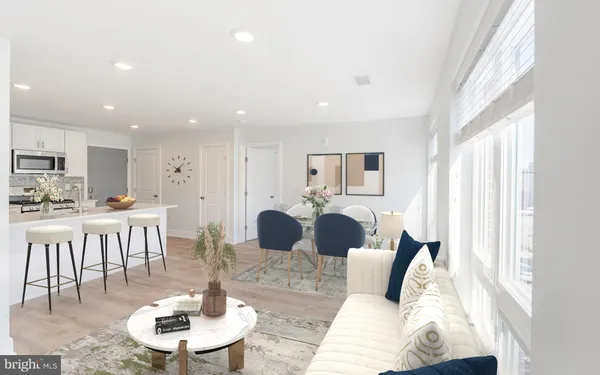 a living room with lots of white furniture and kitchen view