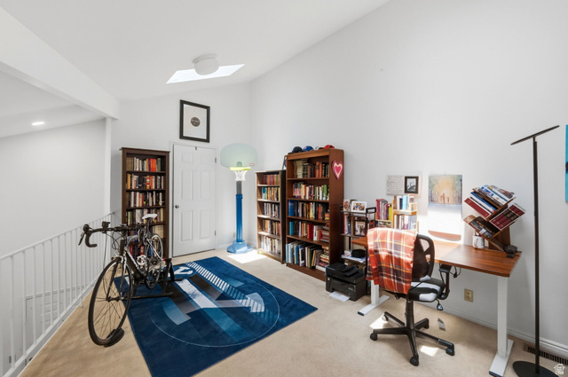 650 South Main Street, Unit 3304 Bountiful, UT 84010 - Photo 15 of 22 Spacious loft area featuring a vaulted ceiling with a skylight, light-toned carpet flooring, a white interior door, white painted walls, and an open railing overlooking the level below