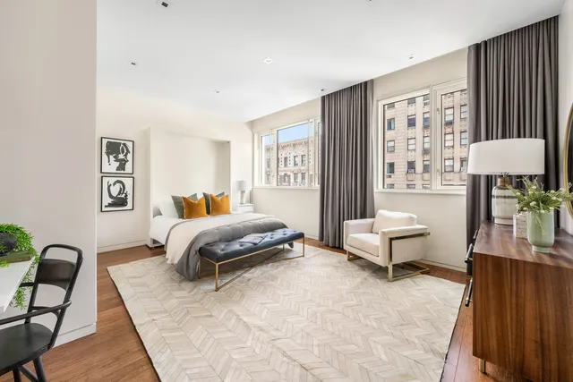 a bedroom with a bed and a dresser next to a window