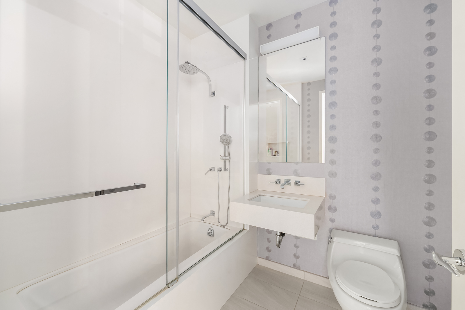 21 East 96th Street, Unit 3/4 Manhattan, NY 10128 - Photo 20 of 25 a bathroom with a toilet a sink a mirror and shower