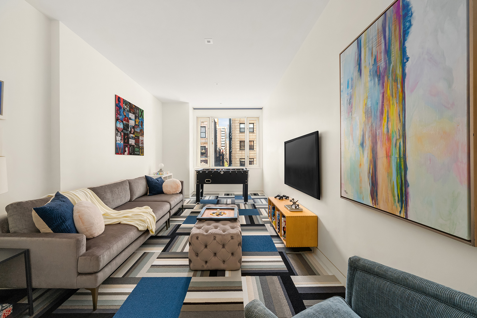 21 East 96th Street, Unit 3/4 Manhattan, NY 10128 - Photo 23 of 25 a living room with furniture and a flat screen tv
