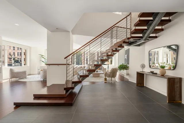 a dining room with wooden floor a chandelier a glass table and chairs