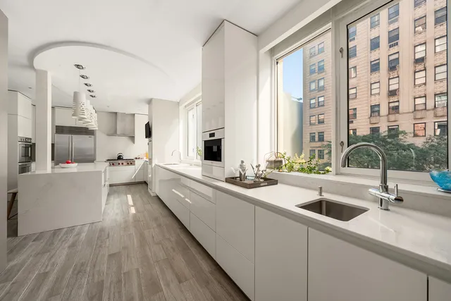 a kitchen with stainless steel appliances granite countertop a stove a sink dishwasher and a refrigerator with wooden floor