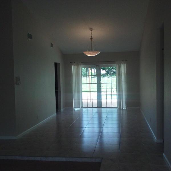 4868 Fox Hunt Trail Boca Raton, FL 33487 - Photo 7 of 8 a view of an empty room with wooden floor and a window