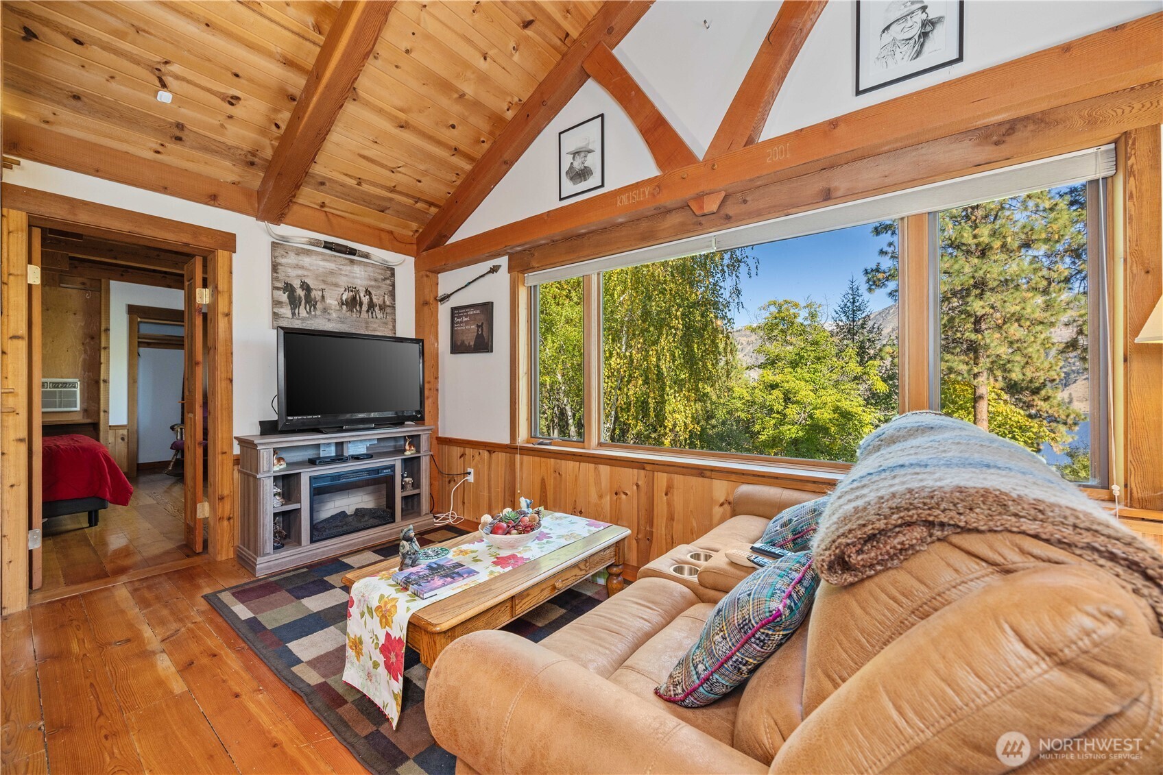 16495 South Lakeshore Road Chelan, WA 98816 - Photo 27 of 40 a living room with couches a flat screen tv and a floor to ceiling window