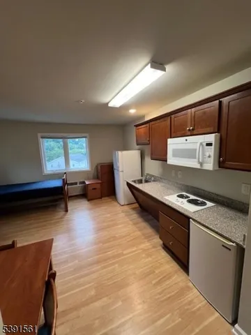 a kitchen with stainless steel appliances granite countertop a stove and a wooden floors