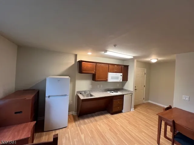 a kitchen with stainless steel appliances a stove top oven a sink and a refrigerator