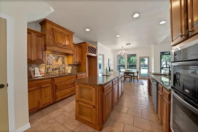 a kitchen with stainless steel appliances granite countertop a refrigerator and a stove top oven