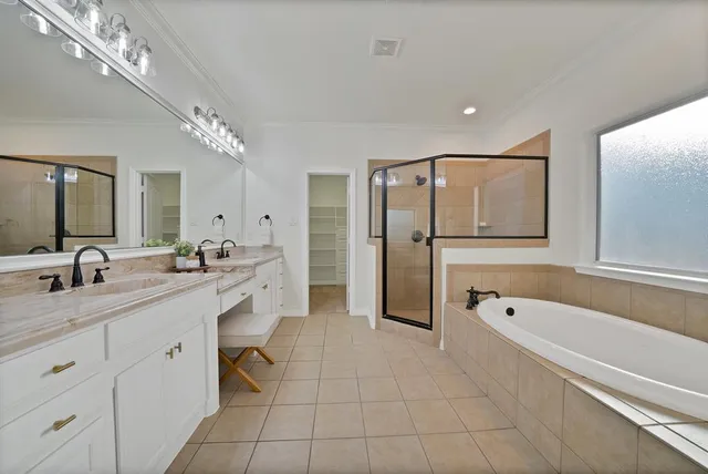 a spacious bathroom with a granite countertop sink a mirror a bathtub and shower
