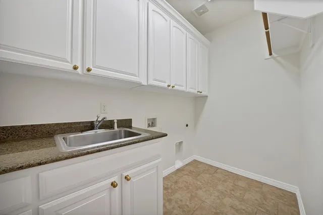 a kitchen with granite countertop a sink and cabinets