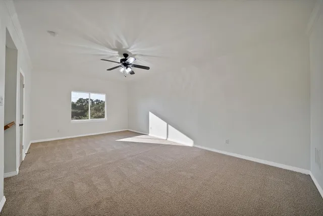 an empty room with a window and a fan