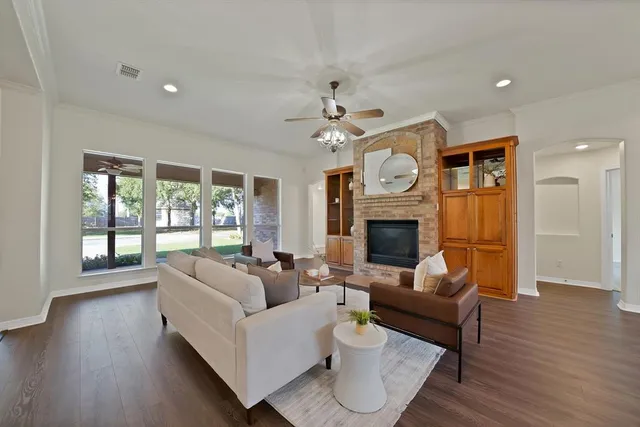 a living room with furniture a fireplace and a ceiling fan
