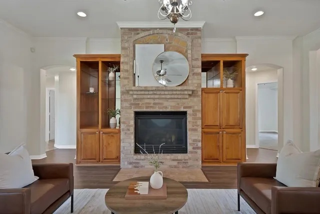 a living room with furniture a fireplace and a chandelier