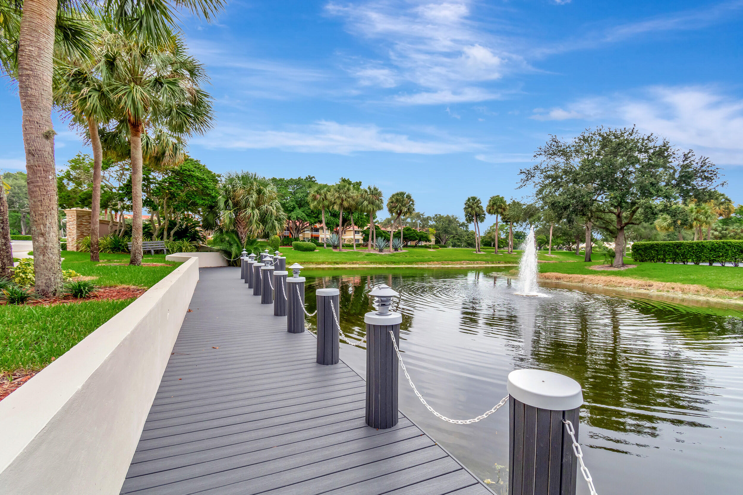 5650 Camino Del Sol, Unit 200 Boca Raton, FL 33433 - Photo 35 of 38 a lake view with a wooden bridge