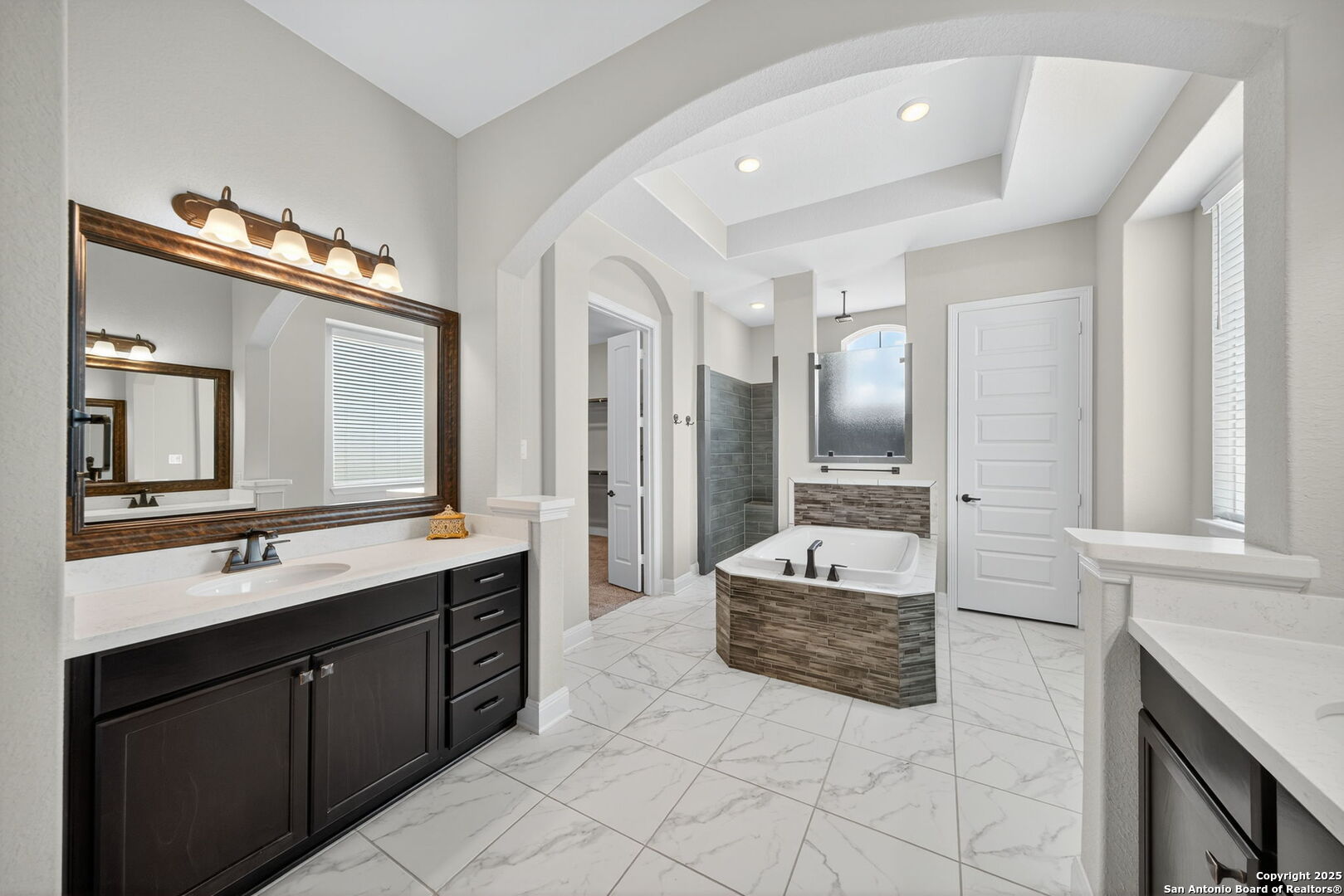 8283 Apache Forest Garden Ridge, TX 78266 - Photo 23 of 42 a spacious bathroom with a double vanity sink a mirror and a bathtub