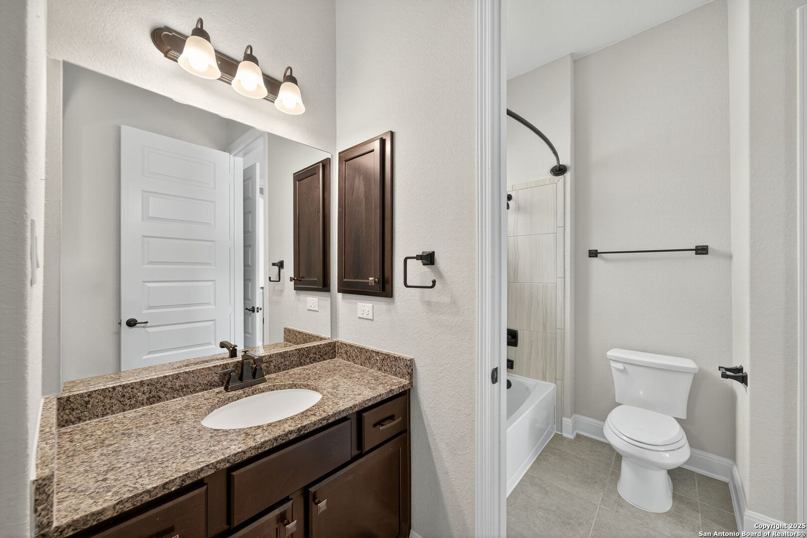 8283 Apache Forest Garden Ridge, TX 78266 - Photo 28 of 42 a bathroom with a granite countertop sink and a mirror
