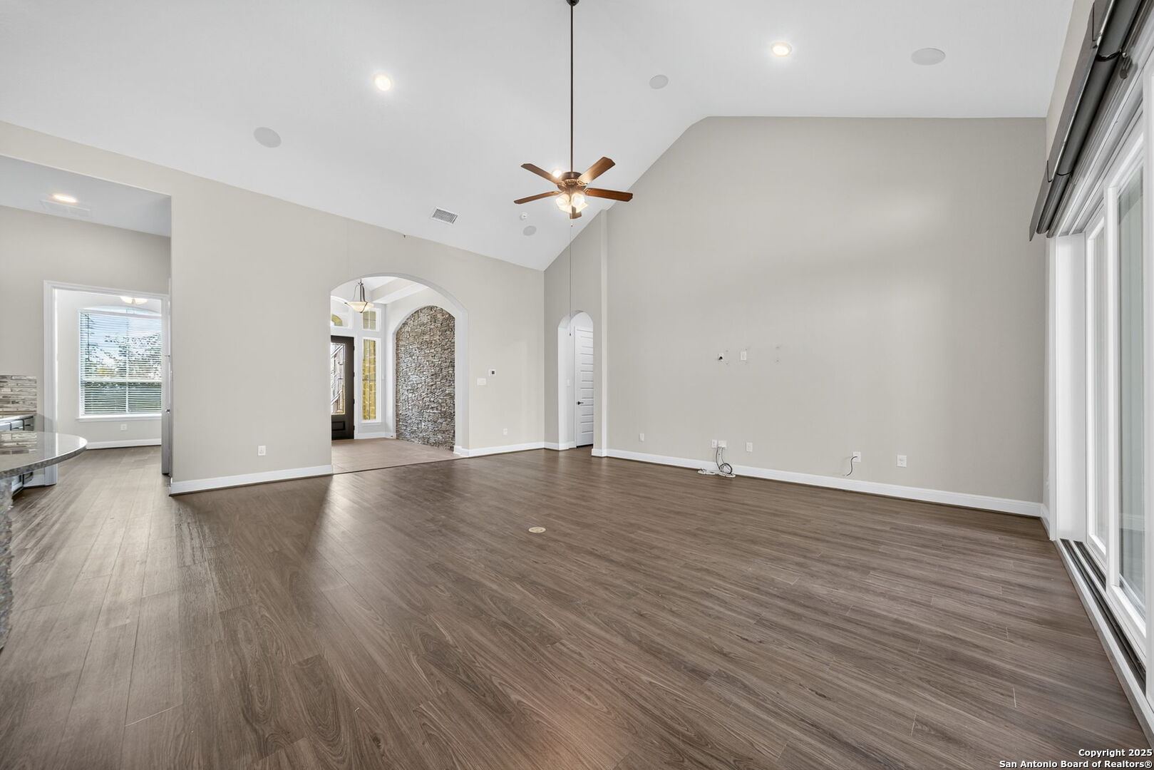 8283 Apache Forest Garden Ridge, TX 78266 - Photo 7 of 42 an empty room with wooden floor chandelier fan and windows