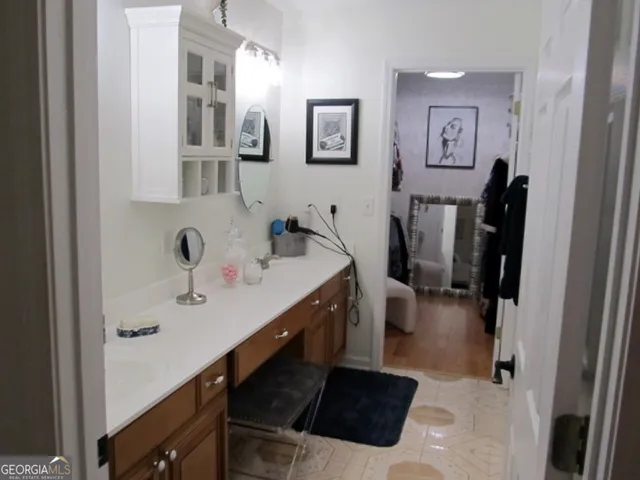 a kitchen with stainless steel appliances a refrigerator a sink a stove top oven a clock and a window