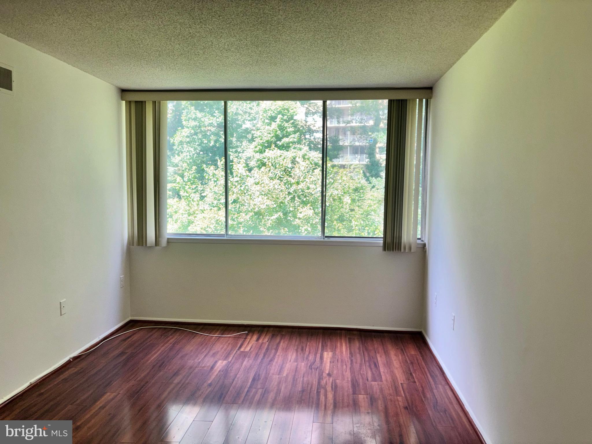 1832 Metzerott Road, Unit 105 Hyattsville, MD 20783 - Photo 15 of 16 an empty room with wooden floor and windows