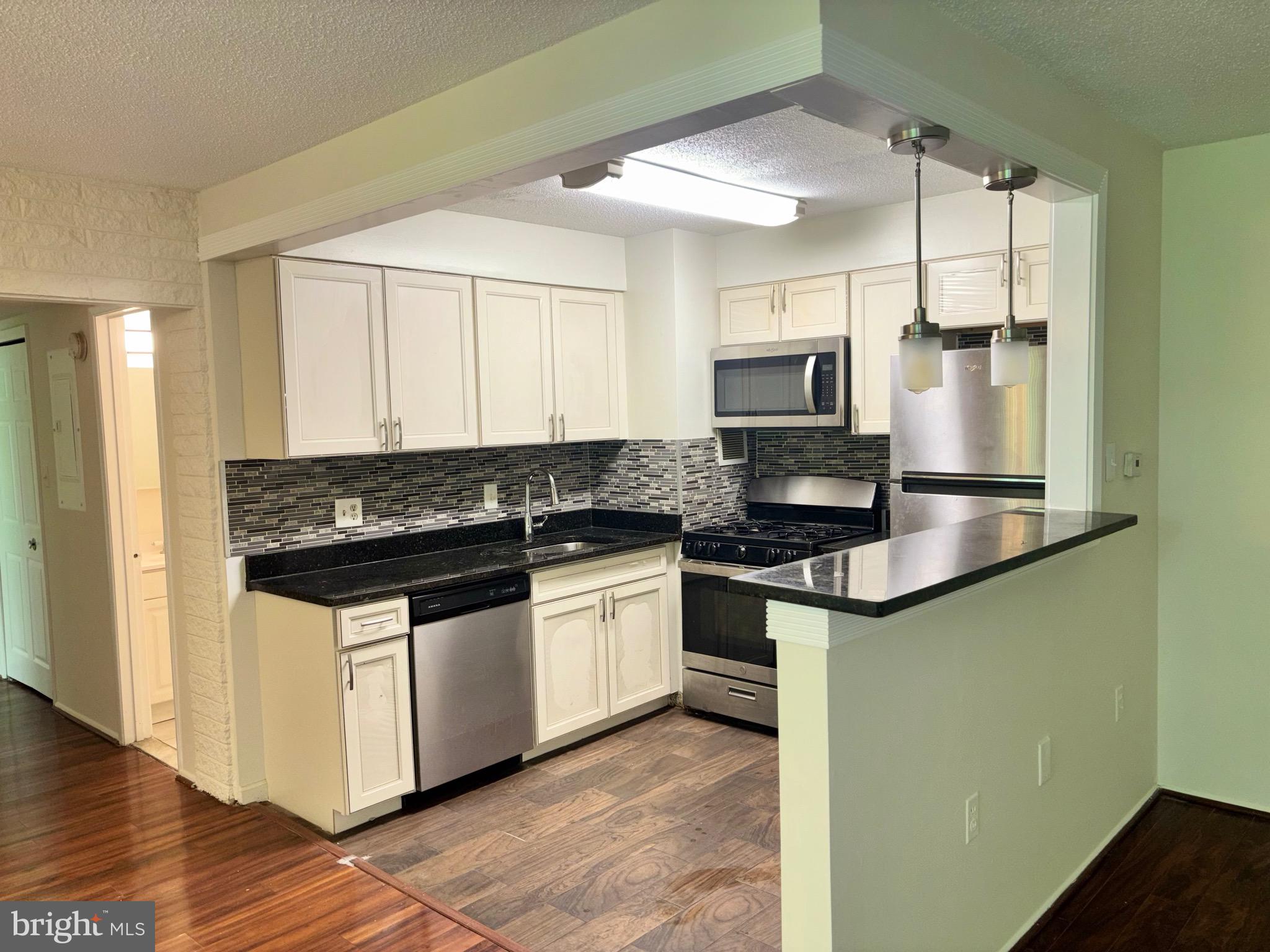 1832 Metzerott Road, Unit 105 Hyattsville, MD 20783 - Photo 4 of 16 a kitchen with stainless steel appliances granite countertop a stove a sink and a microwave