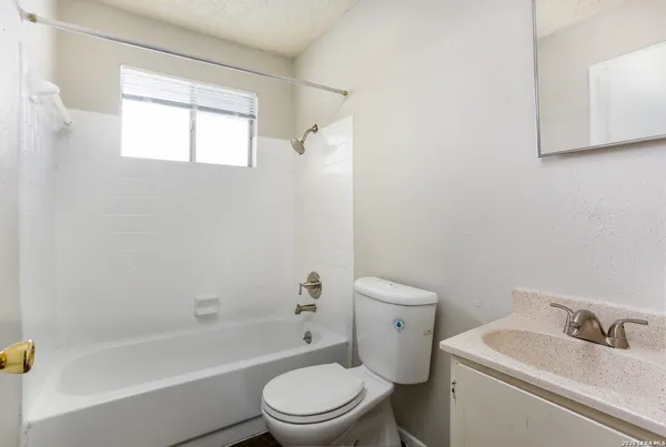 a white toilet sitting next to a bath tub