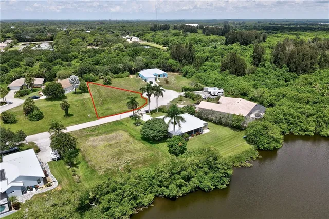 an aerial view of a house with a garden and lake view