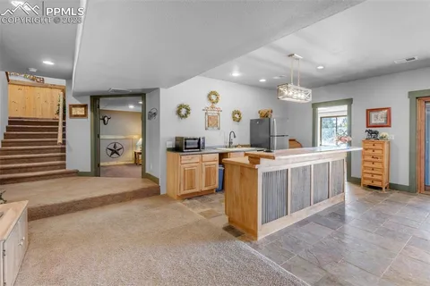 a living room with furniture a flat screen tv and a refrigerator
