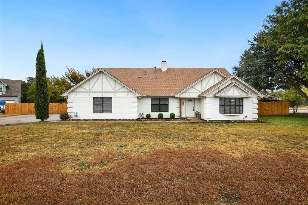 a view of a house with a yard and fence