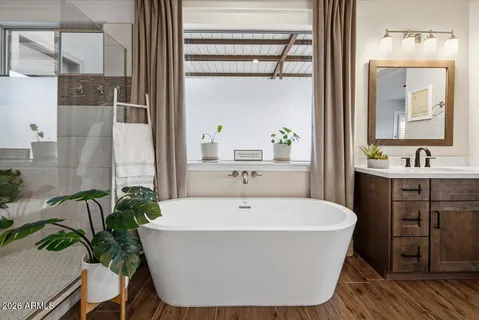 a white bath tub sitting in a bathroom next to a window