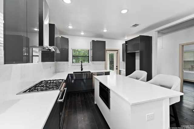 a kitchen with stainless steel appliances kitchen island granite countertop a stove a sink and a refrigerator