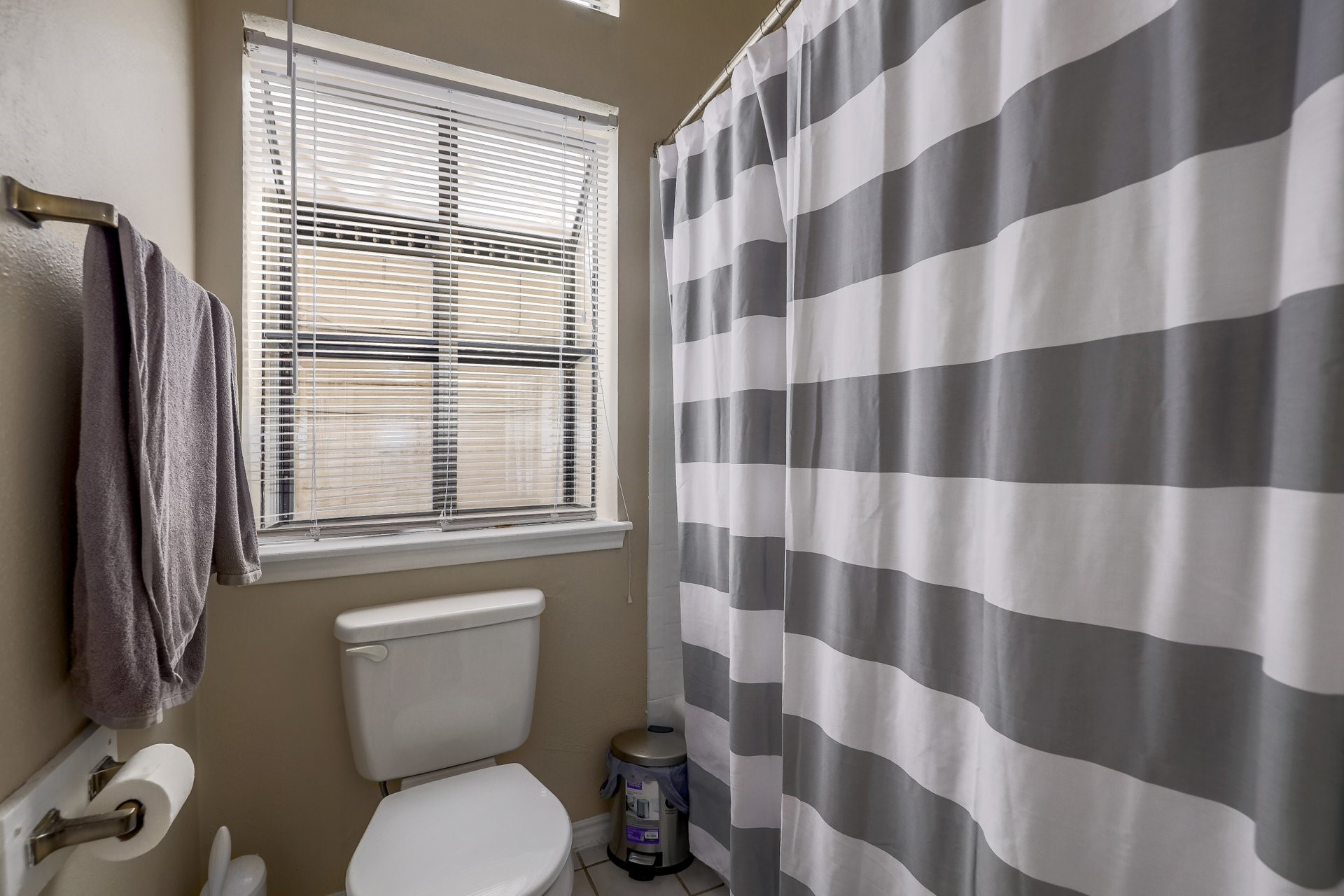 2802 Nueces Street, Unit 101 Austin, TX 78705 - Photo 12 of 20 a bathroom with a toilet and a shower curtain