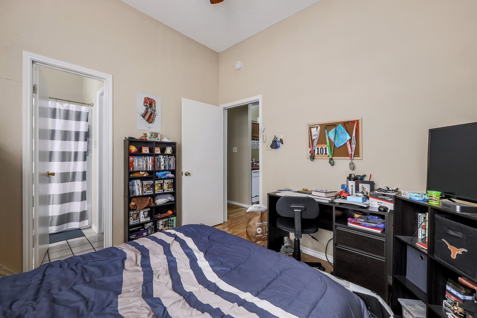 2802 Nueces Street, Unit 101 Austin, TX 78705 - Photo 10 of 20 a bedroom with furniture and a flat screen tv