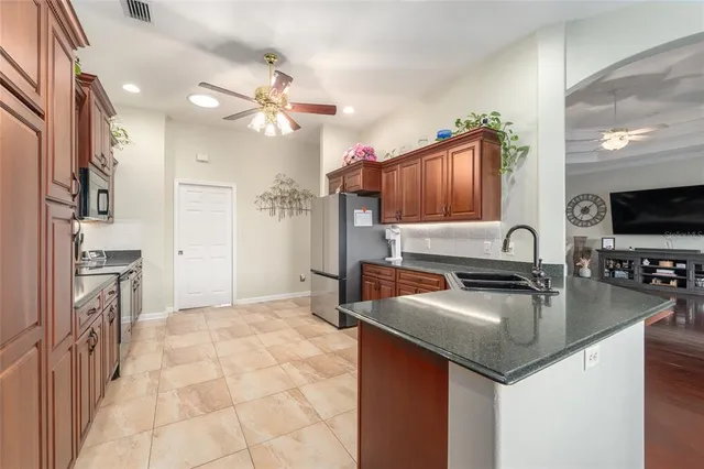 a kitchen with stainless steel appliances granite countertop wooden cabinets a stove top oven a sink and dishwasher