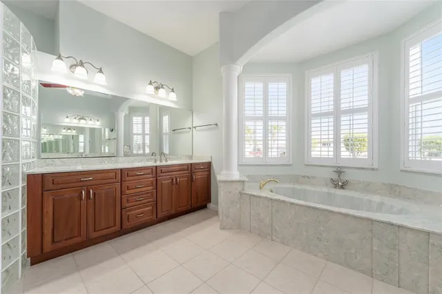 a spacious bathroom with a tub sink and mirror
