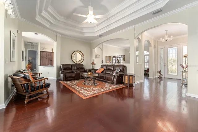 a dining room with furniture a chandelier and wooden floor