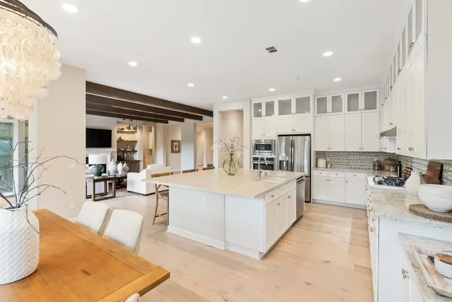 a large white kitchen with a large window and stainless steel appliances