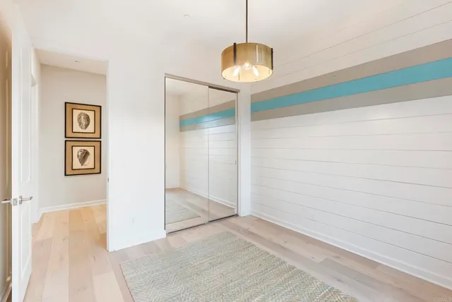 a view of a hallway with wooden floor and chandelier