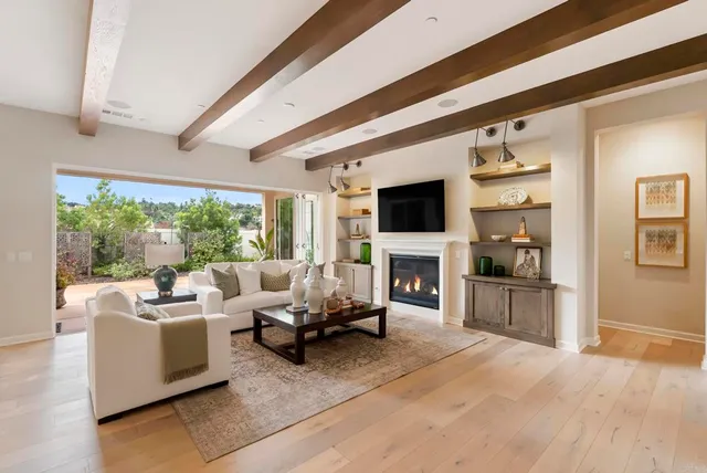 a living room with furniture a fireplace and a floor to ceiling window