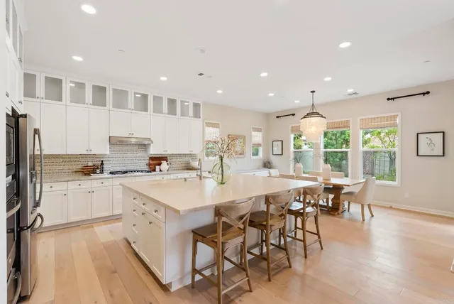 a large kitchen with kitchen island a island a stove a table and chair in it