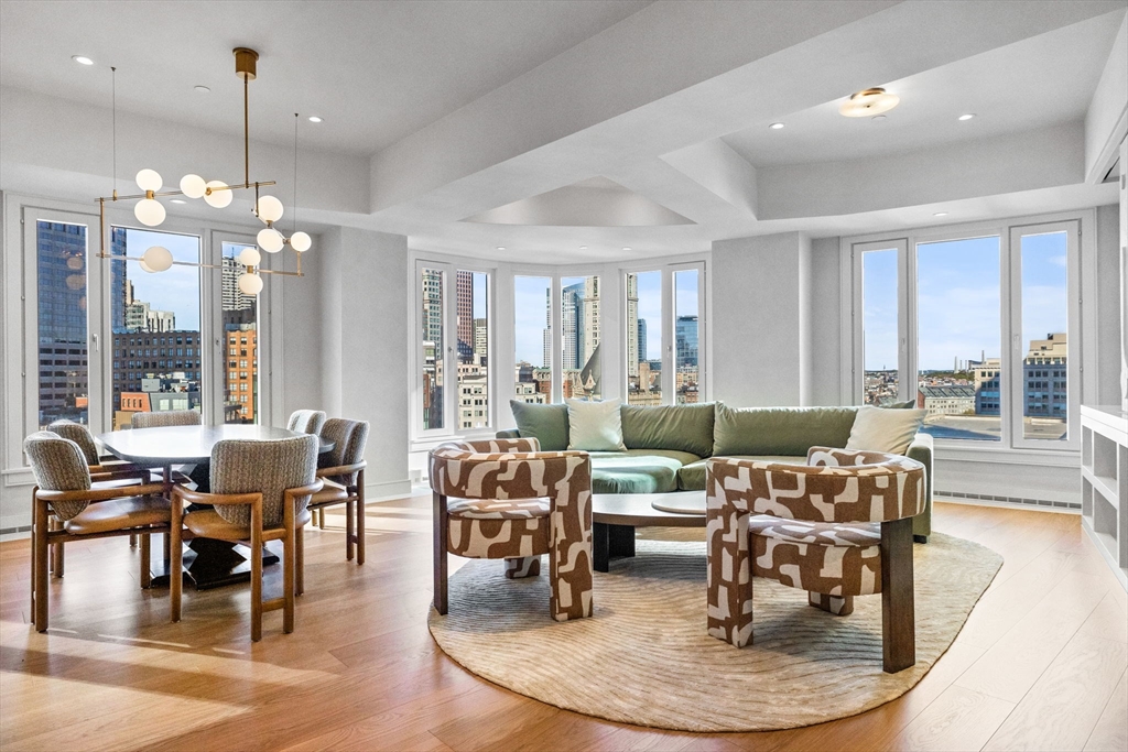 a dining room with wooden floor a chandelier a wooden table and chairs