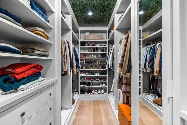 a view of walk in closet with clothes and shoes