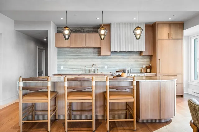 a kitchen with cabinets and chairs